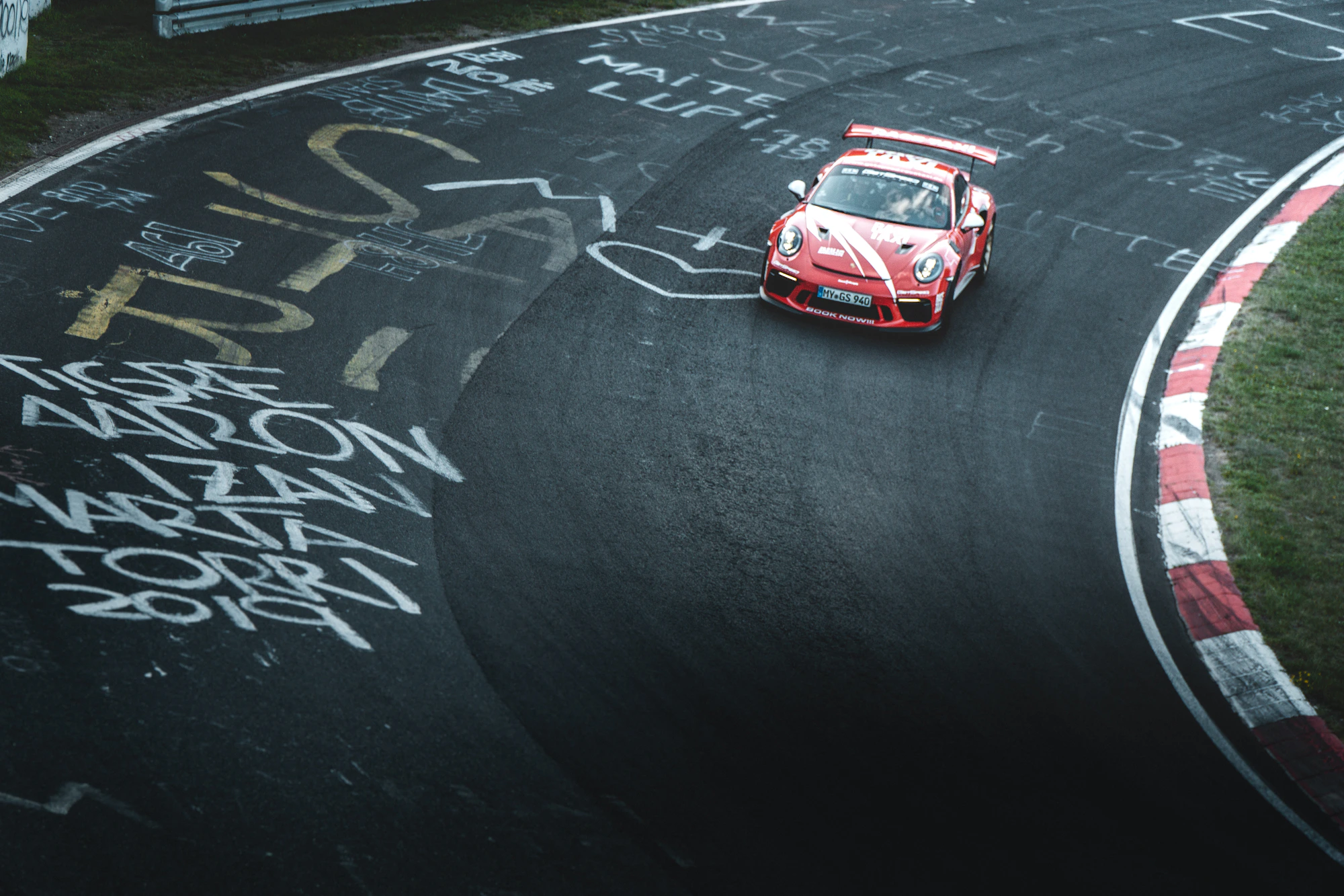 Chiếc Porsche đỏ đang vào cua trên đường đua Nürburgring